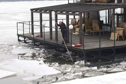 Un hombre trata de romper el hielo que hay debajo de su restaurante flotante en la capital serbia.