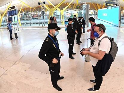 Agentes de la Policía Nacional controlan el acceso a la T-4 del Aeropuerto de Madrid-Barajas, el pasado viernes, para vigilar el cumplimiento de las restricciones a la movilidad impuestas por el estado de alarma decretado en Madrid.