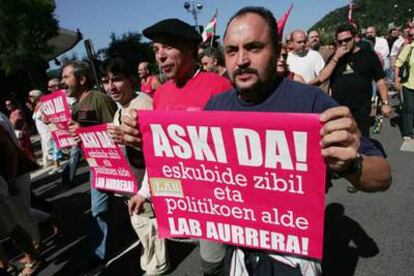 Un manifestante muestra un cartel "a favor de los derechos civiles y políticos" y de apoyo a LAB.