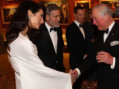 Amal y George Clooney jutno al príncipe Carlos, en el Buckingham Palace el martes.