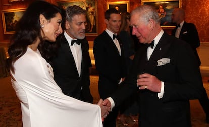 Amal y George Clooney jutno al príncipe Carlos, en el Buckingham Palace el martes.