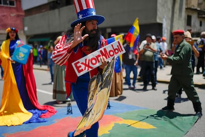 Un hombre vestido como el Tío Sam sostiene un cartel de la petrolera Exxon durante una protesta a favor de anexar el Esequibo, en septiembre de 2023, en Caracas. 