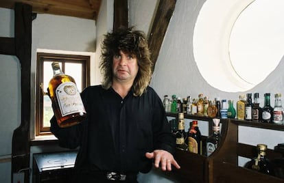 “Cuando voy al médico, lo primero que le digo es: ‘Mire, soy un adicto, soy alcohólico, así que no se crea nada de lo que le cuento”.  En la imagen, Ozzy Osbourne sujeta una botella de whisky en su casa en 1988.