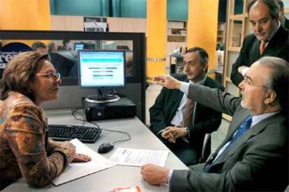 Pedro Solbes (sentado, a la derecha) visita una oficina de la Agencia Tributaria.