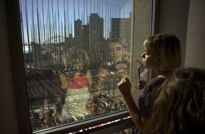 Una niña contempla desde una ventana cómo preparan el escenario donde tendrá lugar la ceremonia en la que John Kerry izará la bandera norteamericana en la embajada de EE UU en La Habana.