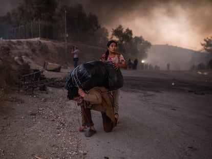 Refugiados cargan lo que han podido salvar del fuego en el campo de refugiados de Moria, en la isla griega de Lesbos.