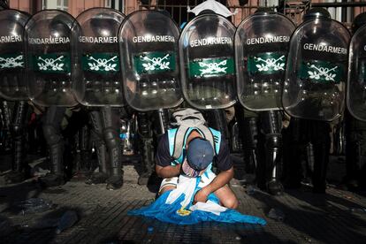 Miles de personas se quedaron fuera de la Casa Rosada, pese a esperar durante horas en la Plaza de Mayo su turno ante el cajón abierto. Las autoridades pidieron incluso el apoyo de la Gendarmería (la policía de fronteras) para contener a la multitud. En la foto, un hincha llora su pena frente a las rejas de la sede del Ejecutivo, el 26 de noviembre de 2020, bajo una fuerte custodia.