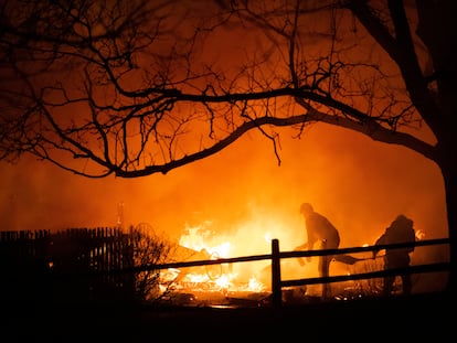 Los habitantes Loiusville intentan apagar las flamas del incendio Marshall el jueves 30 de diciembre de 2021.