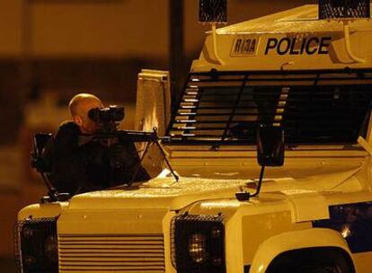 Un policía norirlandés vigila el área donde se produjo el tiroteo de anoche en el que murió un agente, en Craigavon.