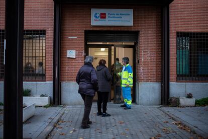 Dos pacientes y un sanitario en la entrada del centro de salud de Villaverde, este viernes.