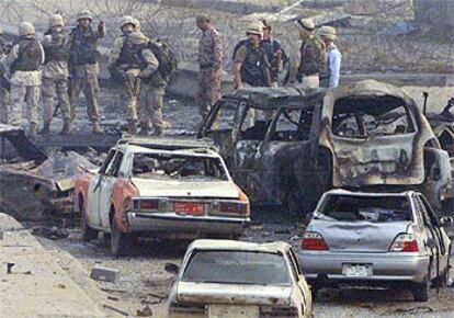 Soldados estadounidenses buscan pruebas entre los restos de los coches tras el atentado suicida de ayer en Bagdad.