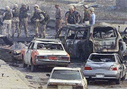 Soldados estadounidenses buscan pruebas entre los restos de los coches tras el atentado suicida de ayer en Bagdad.