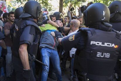 Un manifestante es retenido por agentes de la policía nacional durante la concentración frente de la sede de la Cup.