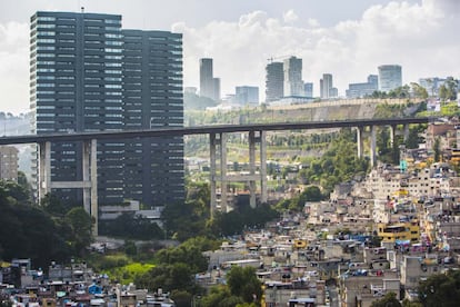 Una autopista elevada separa una barriada humilde de unos edificios de lujo.