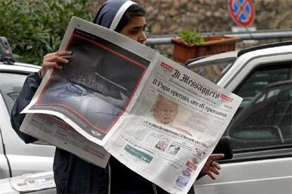 Una monja lee en un periódico romano la noticia de la operación de Juan Pablo II.