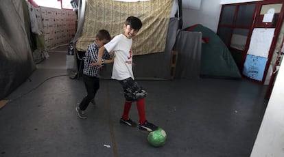 Dos niños juegan en el campamento de refugiados del antiguo estadio de hockey Olympic Complex, en Atenas.