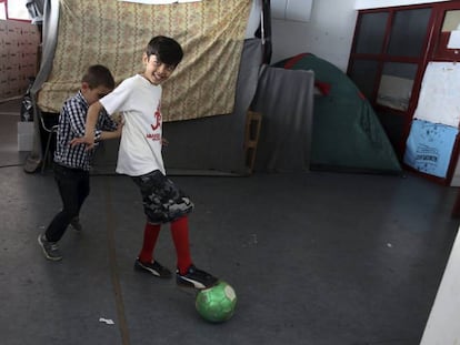 Dos ni&ntilde;os juegan en el campamento de refugiados del antiguo estadio de hockey Olympic Complex, en Atenas.