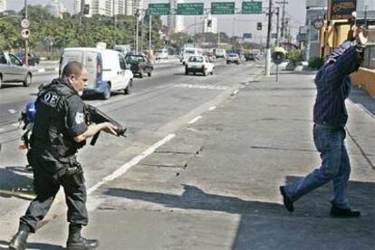 Un policía da el alto a un sospechoso en el barrio de Jardim Elba ayer en São Paulo.