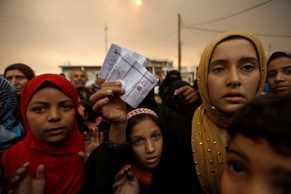 Una mujer muestra su documento de identificación de refugiada mientras se queja de la falta de alimentos, en las cercanías de un campamento temporal al sur de Mosul (Irak).