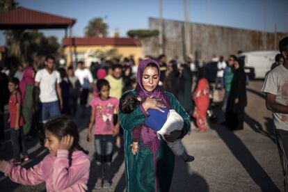 Una mujer siria abraza a su hijo a las puertas del CETI de Melilla. 