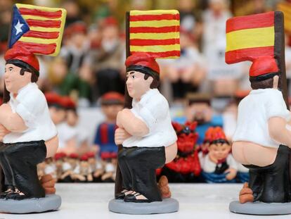 Imagen de tres 'caganers', tradicionales figuras del Belén en Cataluña, portando una estelada, una senyera y una bandera española.