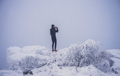 Un hombre toma fotografías del paisaje desde una roca en la montaña Grosser Felberg (Alemania) el 15 de enero de 2017.