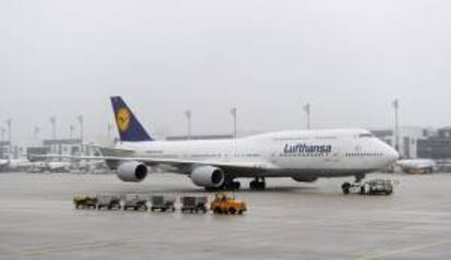 Un remolcador de aviones tira de un Boeing 747-8 de Lufthansa en el aeropuerto de Mnich (Alemania). EFE/Archivo