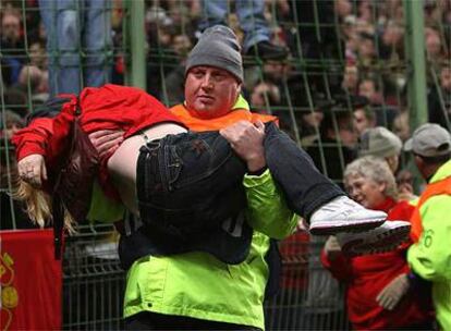 Un miembro de seguridad rescata a una de las mujeres que se desmayó tras la presión de los aficionados