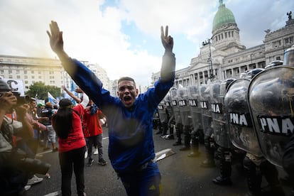 Un hombre pide calma frente al primer cerco de la policía que custodiaba el Congreso. 