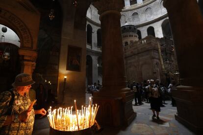 Un peregrino enciende una vela en el interior de la iglesia del Santo Sepulcro, en la Ciudad Vieja de Jerusalén. En el último año y medio, y a pesar de que el shequel (la moneda oficial usada en Israel) se ha revaluado un 12% respecto al euro, la cifra de visitantes no ha parado de aumentar.