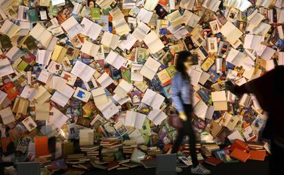 Una joven pasa por un mural cubierto de libros durante la apertura este miércoles de la Feria del Libro de Erbil, capital del Kurdistán (Irak). Más de 300 expositores de 20 países participarán en la feria, que se celebrará hasta el próximo 13 de abril.