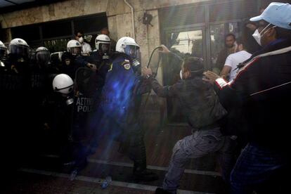 Policías y manifestantes se enfrentan en las calles de Atenas, durante la primera jornada de los dos días de huelga general convocados en el país.