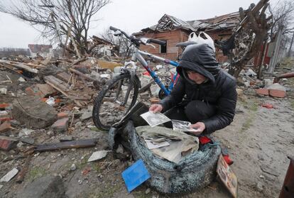 Una mujer local revisa las fotos familiares que encontró entre los escombros de su casa bombardeada en Chernihiv, en el norte de Ucrania. La Fiscalía de Menores del país ha denunciado que al menos 177 niños han muerto y 336 han resultado heridos en ataques perpetrados por Rusia desde el comienzo de la invasión, el 24 de febrero, hasta este domingo.
