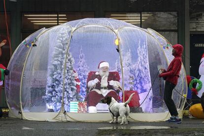 Un hombre vestido de Santa Claus permanece sentado en el interior de una burbuja de plástico en el vecindario de Greenwood en Seattle (EE UU), el 8 de diciembre.