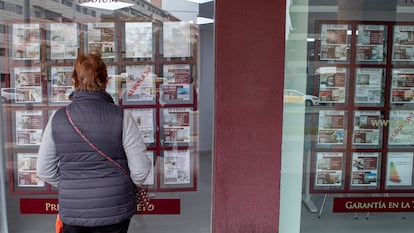 Una mujer mira los anuncios de compraventa de pisos en una inmobiliaria de Sevilla.