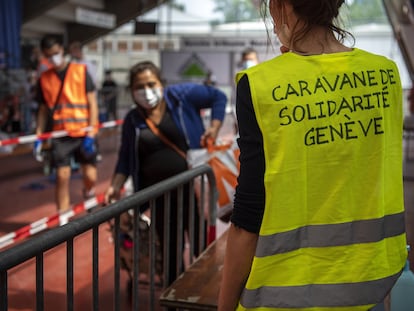 Una voluntaria reparte alimentos y productos de primera necesidad en Ginebra (Suiza).