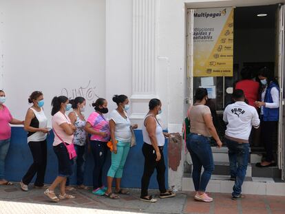 Habitantes de Santa Marta, Colombia, hacen fila afuera de un banco.