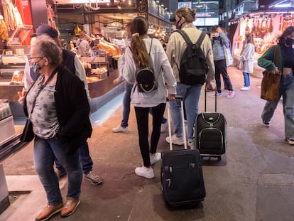 BARCELONA 2021/05/17 
Turismo en Barcelona tras superar los peores momentos de la pandemia del  Covid-19. En la imagen, dos turistas italianos paseando por el mercado de la Boqueria acarreando maletas.  *Foto:Carles Ribas* 