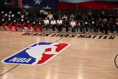 Los jugadores de Phoenix y Washington, ante el logo de la NBA, en un partido en julio de 2020.