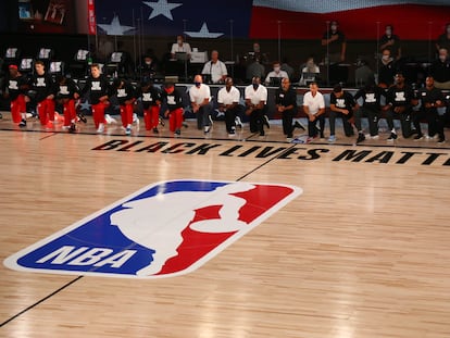 Los jugadores de Phoenix y Washington, ante el logo de la NBA, en un partido en julio de 2020.