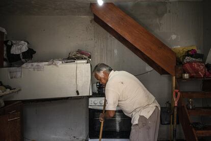 Un hombre limpia dentro de su casa junto a sus electrodomésticos que fueron arrastrados por el agua.