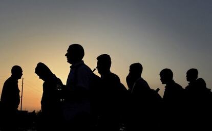 Refugiados esperan para entrar en un campamento en Macedonia.