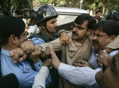 Un activista de los derechos humanos forcejea contra la policía en Islamabad.