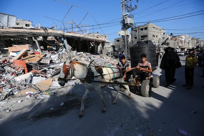 Palestinos caminan entre los edificios derruidos, tras un ataque israelí, este martes en Rafah. 