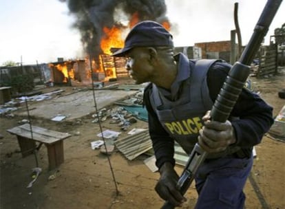 Un policía vigila una zona de chabolas a las afueras de Johanesburgo donde los inmigrantes fueron atacados.