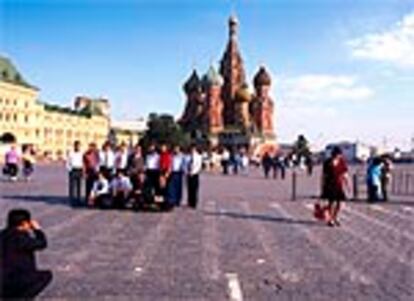 Un grupo de turistas se fotografía delante de la iglesia ortodoxa de San Basilio, del siglo XVI y uno de los iconos de la plaza Roja de Moscú por sus cúpulas en forma de bulbo.
