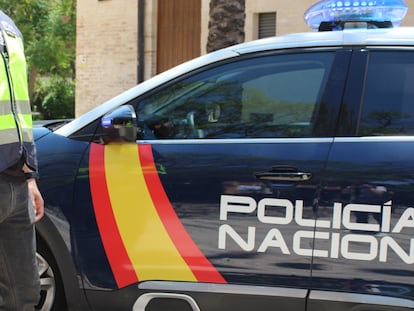 Un agente junto a un vehículo de la Policía Nacional. Efectivos de la UDEF registraron la sede de la policía local de L'Hospitalet hace diez días.