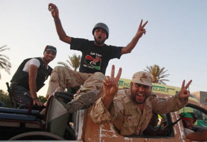 Combatientes libios rebeldes pasean por la localidad de Maia tras avanzar en las afueras de Trípoli.