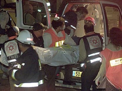 Un equipo de emergencia introduce en una ambulancia el cadáver de una víctima del atentado suicida de Netania.