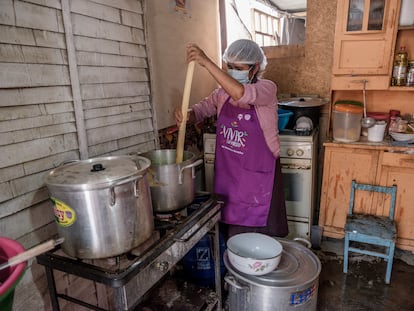 Una mujer en la asociación de vivienda Paraíso, en la periferia norte de Lima, cocina como parte de olla común, una iniciativa comunitaria vecinal de respuesta a la necesidad alimentaria.